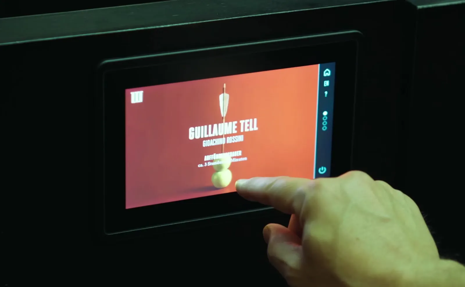 Musiktheater Linz: a finger taps a seat display showing the page for Gioachino Rossini’s “Guillaume Tell”